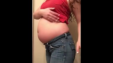 Hot brunette with a round stuffed belly in red top