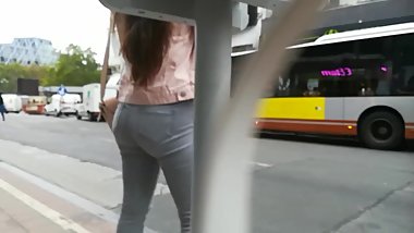 Teen in grey jeans waiting on the bus